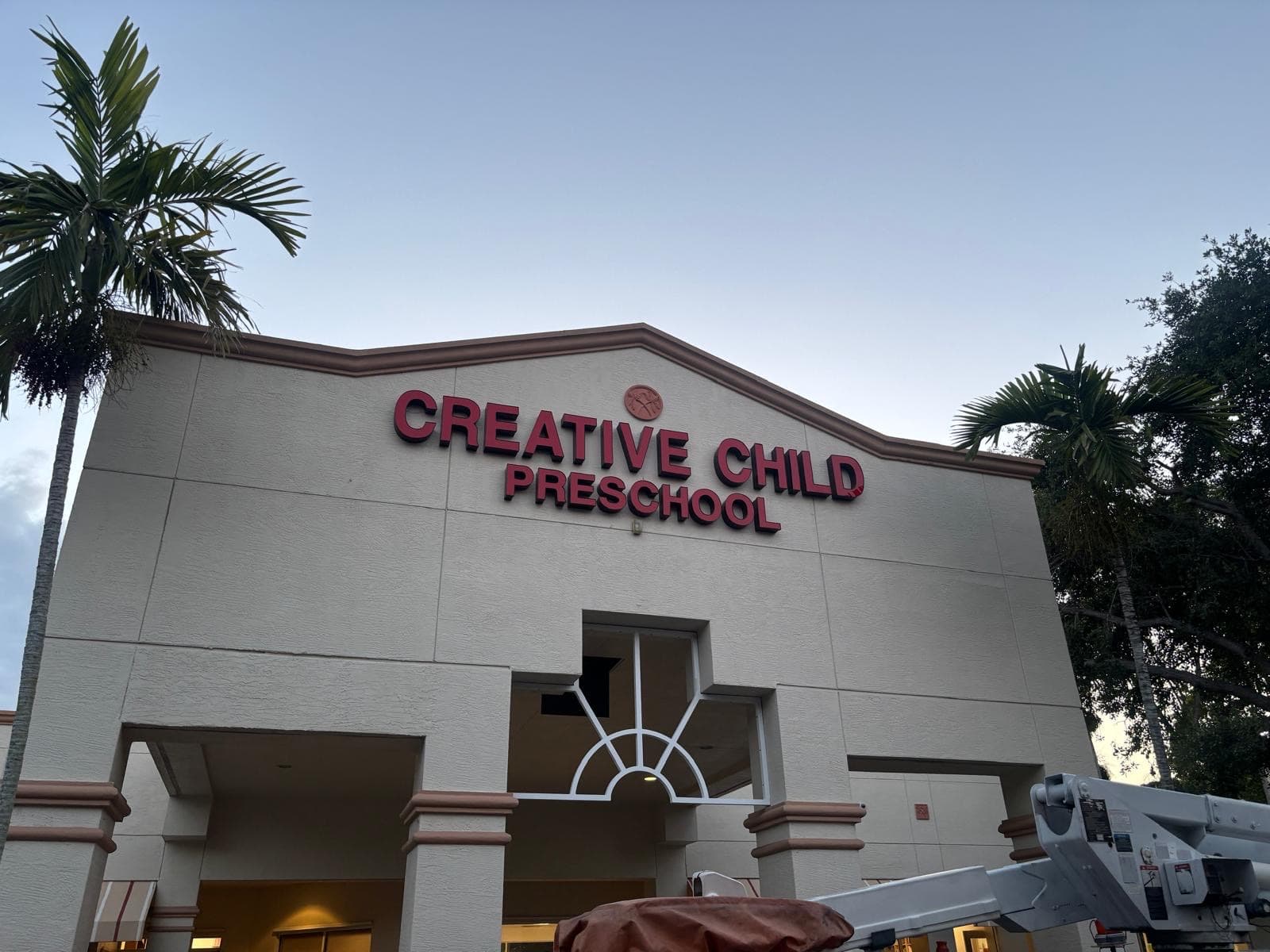 A repaired storefront sign at dusk with every letter back in place, a Ghost Crown Electric relight