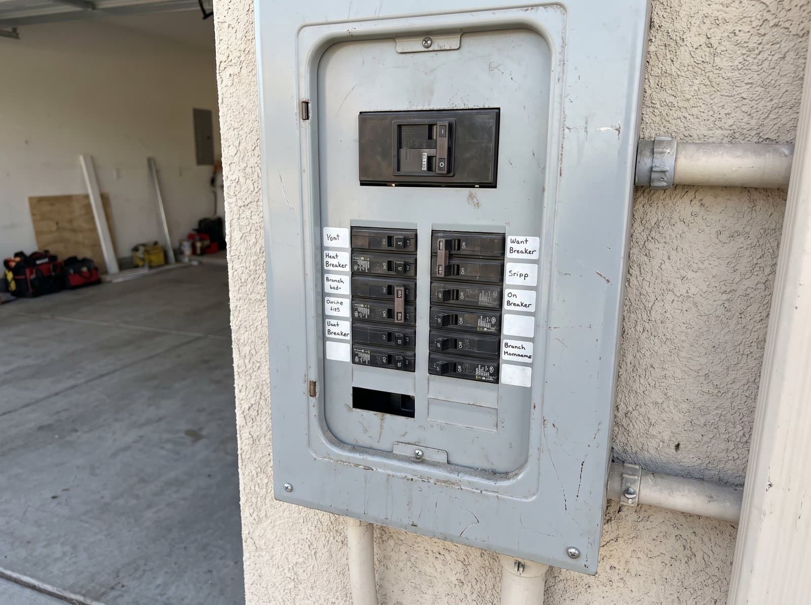 A residential panel with the door open and the main breaker in the tripped position, in daylight
