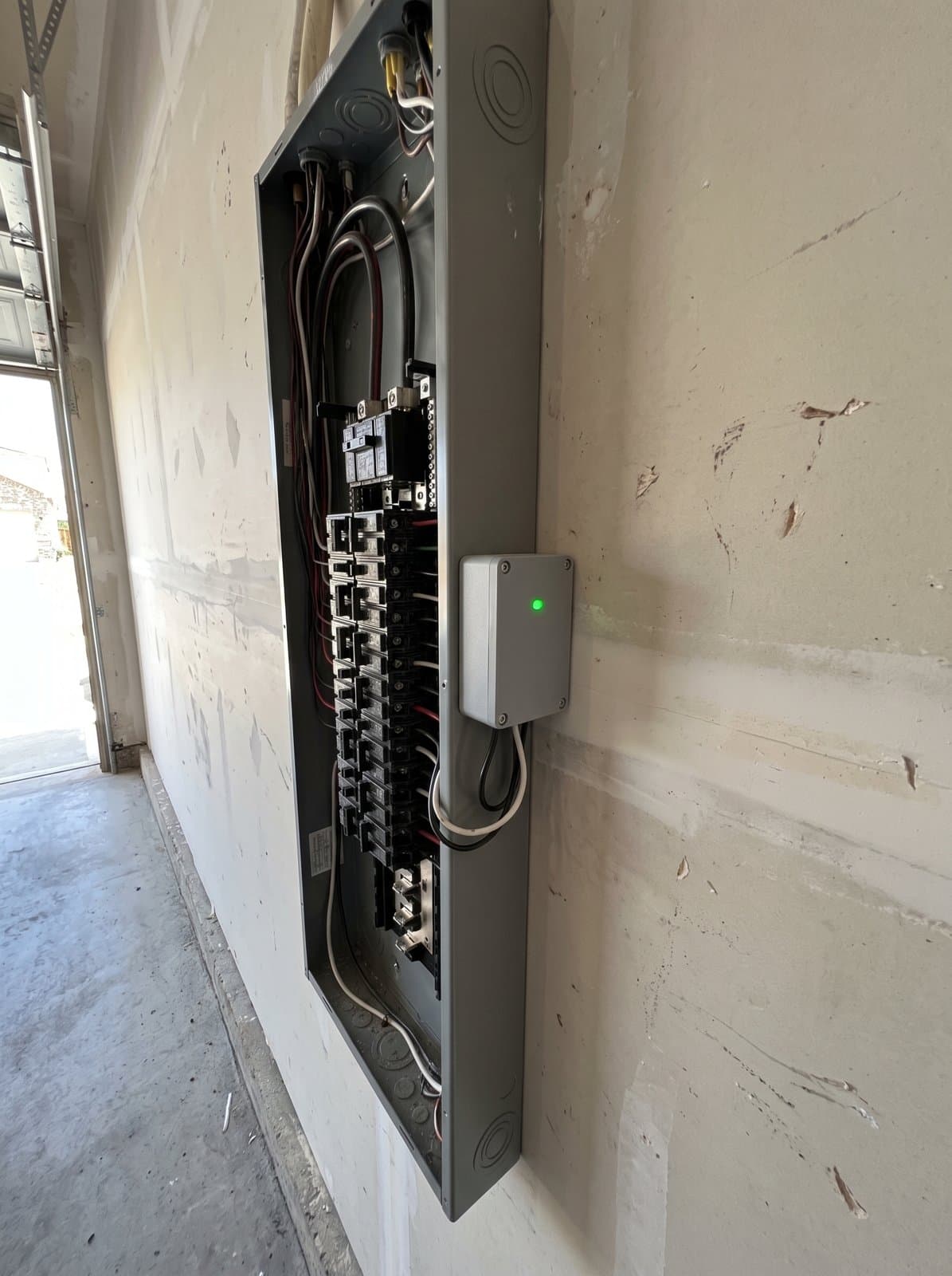 A whole home surge protective device mounted beside an open residential panel and wired to its own breaker