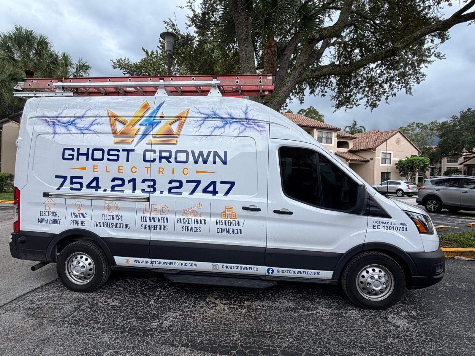 The Ghost Crown Electric service van, wrapped with the crown logo, phone number, and the services the crew covers